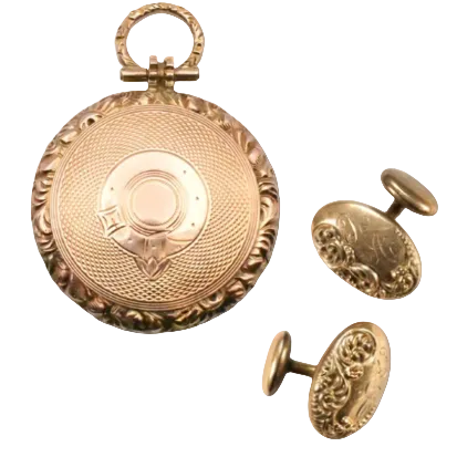 A gold-toned engraved pocket watch case with a hanging loop, shown alongside matching oval cufflinks on a light gray background.