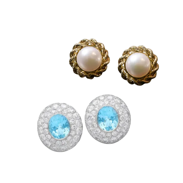 Three pairs of stud earrings on a light gray background: two gold-tone earrings with round white pearls, and one silver-tone oval earring with a light blue center stone surrounded by clear stones.